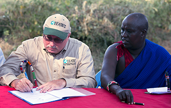 Azzedine Downes, International Fund for Animal Welfare (IFAW) President (left) and Mr. Daniel Leturesh,  representing the Maasai: sign the Kitenden Corridor certificates after they signed a lease agreement, 17 July 2013, in Amboseli National Park in Kenya. Photograph © IFAW/K. Prinsloo.